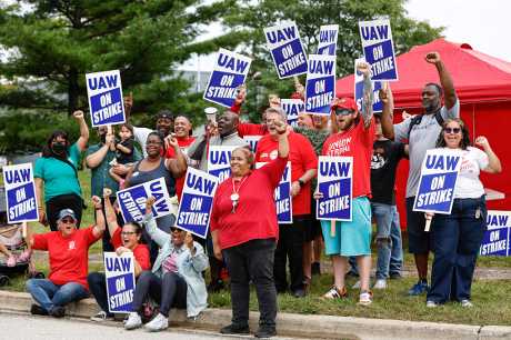 UAW工会成员在密歇根州的通用汽车组装厂附近举著纠察牌。美联社