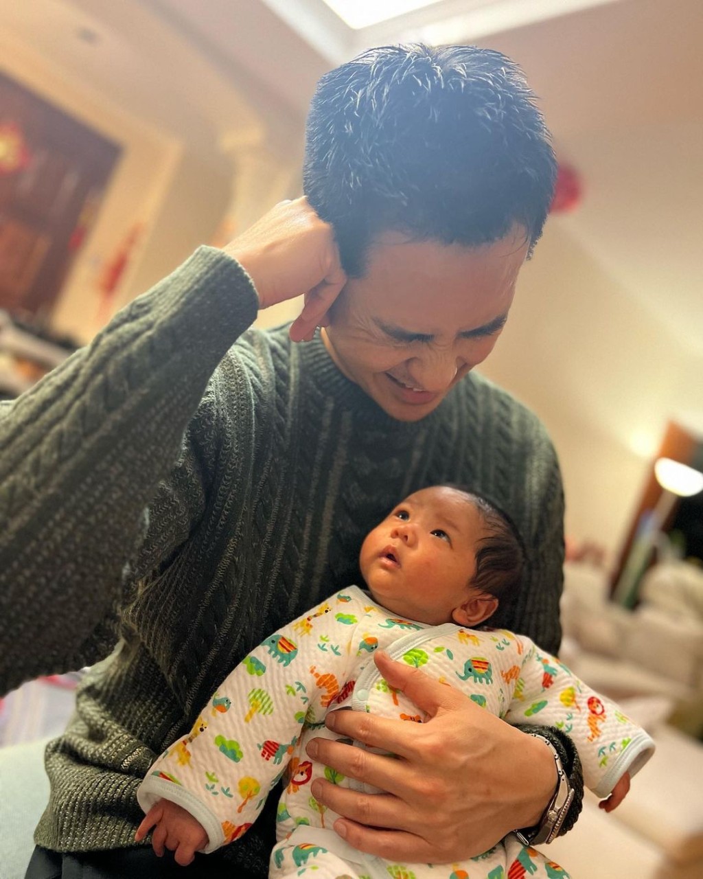 陈凯琳又分享老公郑嘉颖抱着Carlos的照片，郑嘉颖装出头痛表情，似乎想表达照顾婴儿很辛苦。