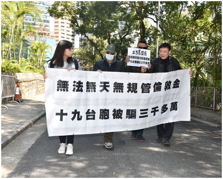 兩名台灣的倫敦金騙案苦主携橫額到禮賓府遞交請願信。