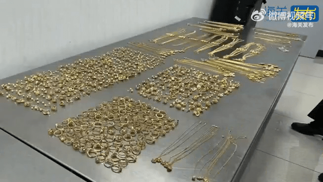 铺满了一桌的黄金金饰，共计699件。