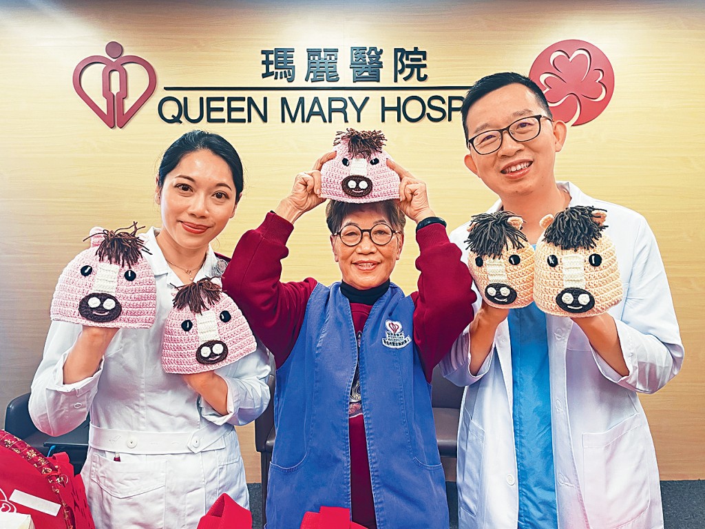 瑪麗醫院義工張玉蓮（中）及醫生蘇文庭（右），分別透過編織冷帽及創作對聯，向馬年寶寶及新年期間仍需住院的寶寶送暖。