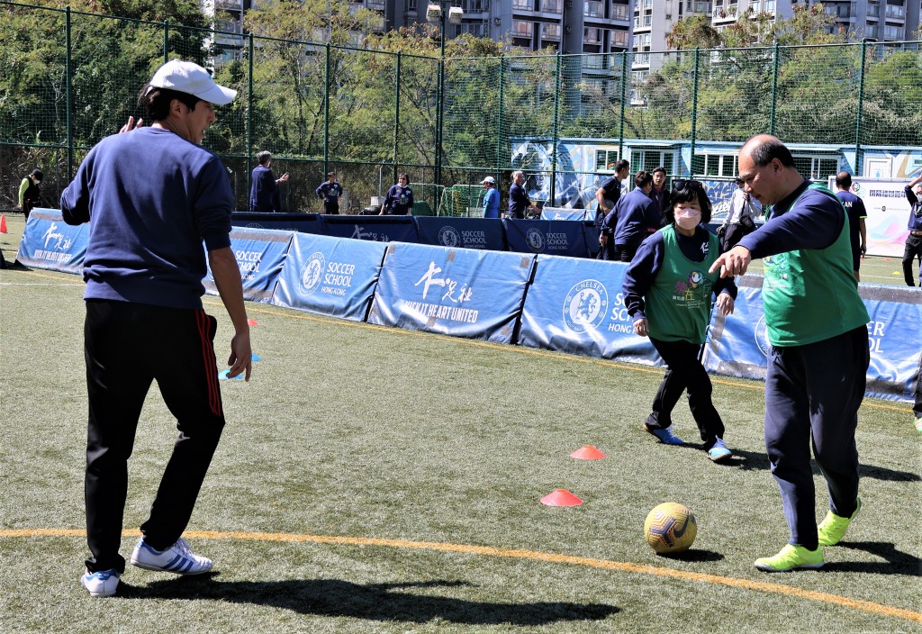  參加者在教練（戴帽者）指導下合作以顏色飛碟傳球。  陸永鴻攝 