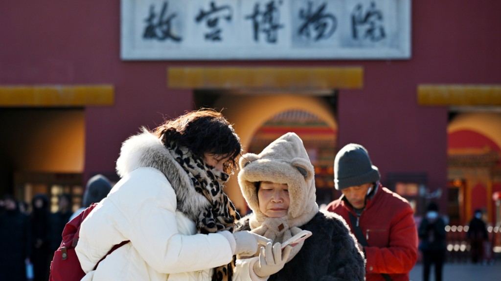 身著禦寒冬裝的遊客在北京故宮博物院神武門。中新社