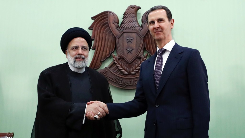 伊朗总统莱希（左）与敍利亚总统阿萨德握手。 美联社