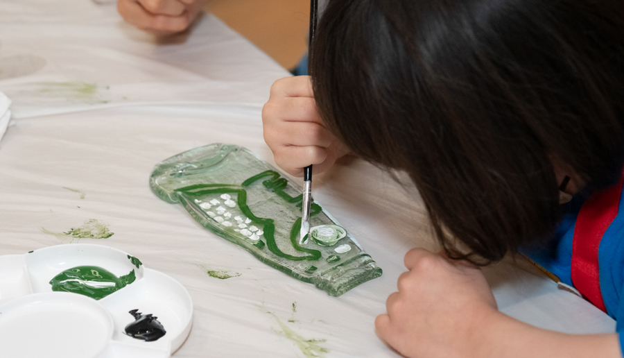 小朋友运用各种颜料于预先压平的玻璃瓶绘画不同图案。