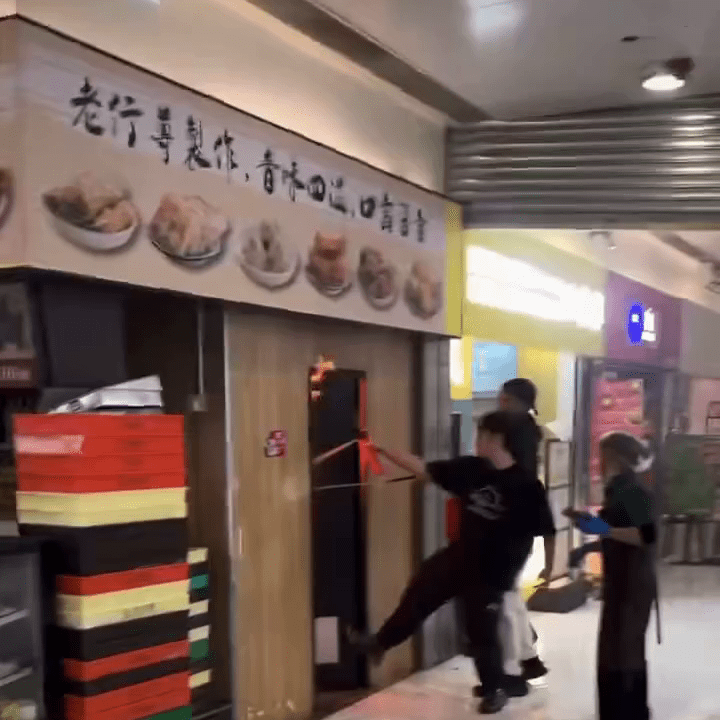 火舌涌出店舖，有男子持小型灭火筒试图救火。IG：mingkeeblacklamb