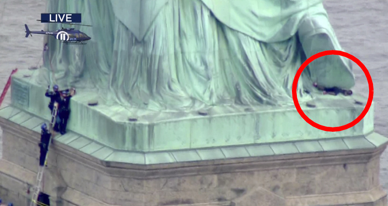 女子爬上紐約自由女神像。AP