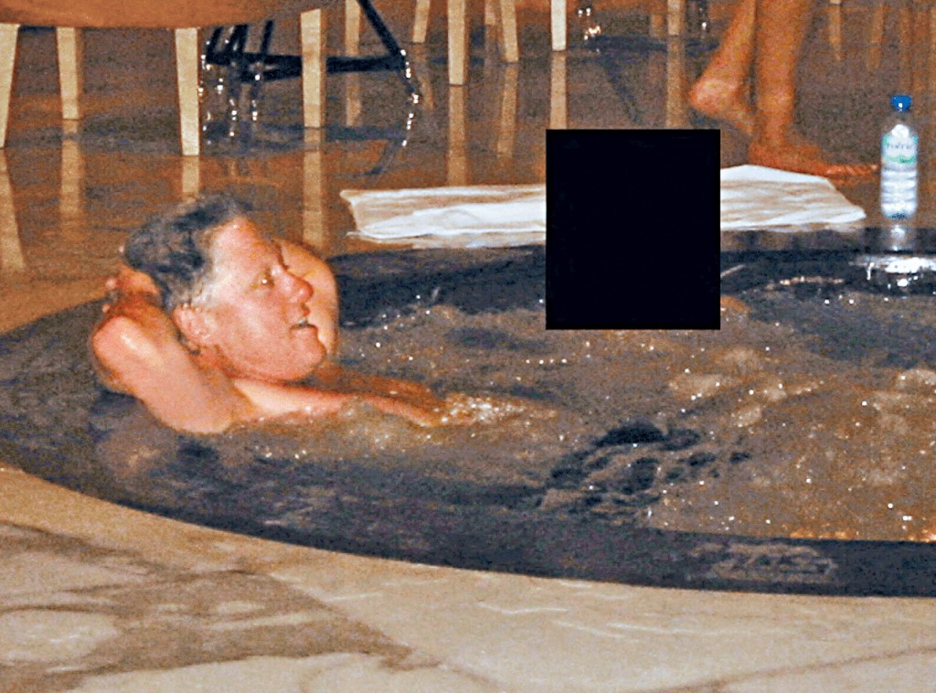 相中克林顿躺在按摩浴缸里，旁边一人脸部被黑色方块遮住，据报是一名女子。