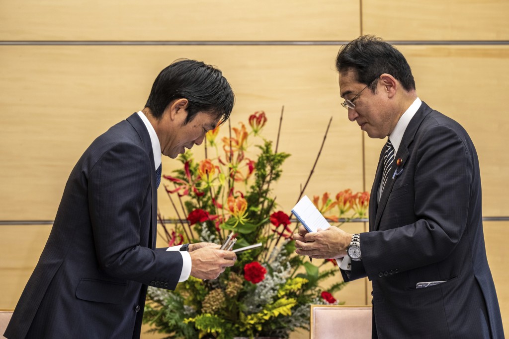 岸田文雄(右)與日本主帥森保一(左)交換筆記本。AP
