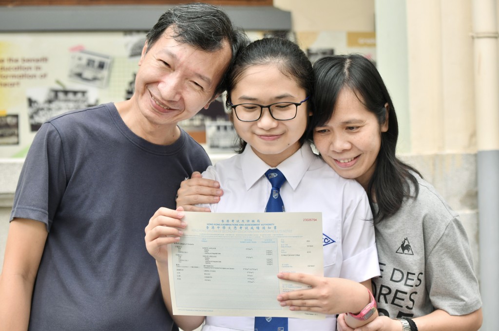 鄒思悅在父母陪同下返母校領取成績單。盧江球攝