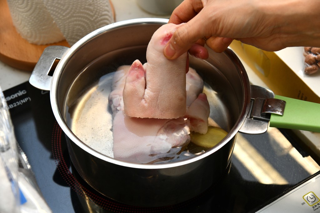 Step 3: 豬手連薑片汆水五分鐘，瀝乾。Blanch the pork knuckles with ginger slices in boiling water for 5 minutes. Drain well.
