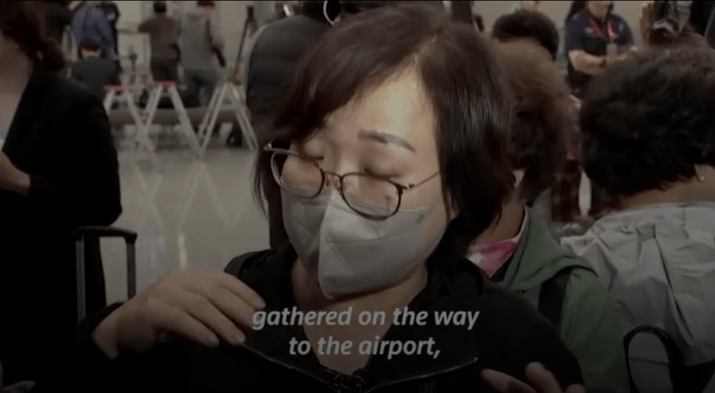一名乘搭政府專機返抵南韓的女遊客接受媒體訪問。路透社