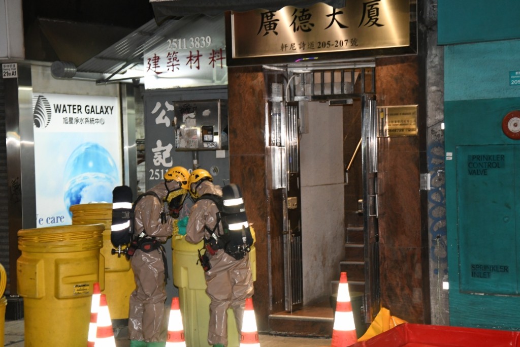 消防員穿上核生化防護袍及戴上呼吸器進入大廈內。李家傑攝