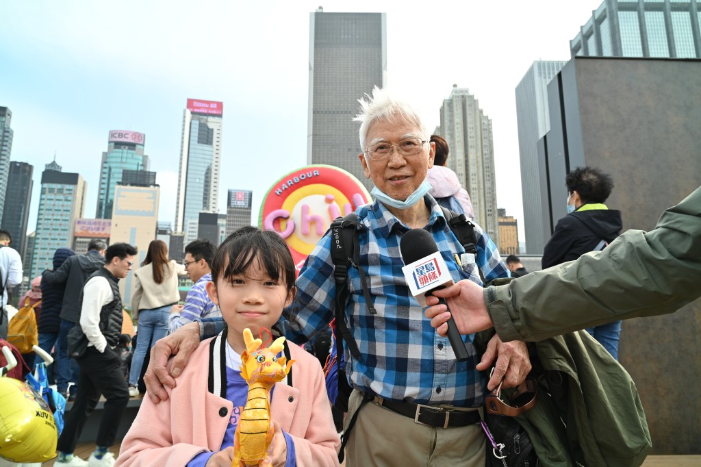 李先生(右)的孫女(左)幸運地撿到金龍吉祥物公仔，直言「好開心」。鍾健華攝