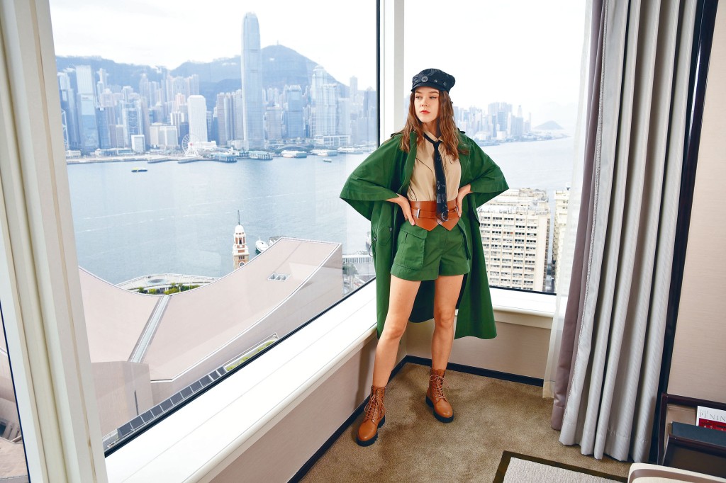 ●鉚釘裝飾黑色報童帽、軍綠色大褸、卡其色恤衫、軍綠色短褲、啡色通花牛皮靴、啡色粗身皮帶、黑色網紗領帶。