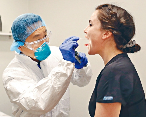 亞利桑那州斯科茨代爾市醫院內醫生為一名行政助理檢驗新冠肺炎。