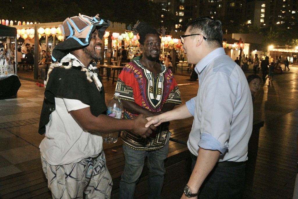 鄧炳強與來自非洲的遊客聊天。陳浩元攝