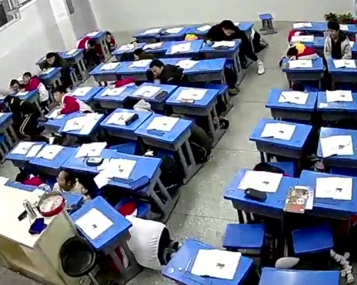 內江威遠縣一班中學生迅速採取避險措施，全員應聲躲避到課桌下。(網圖)