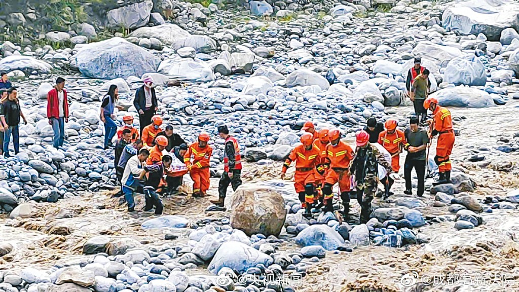 四川泸定县发生地震。图为救搜人员昨午用担架救出伤者。