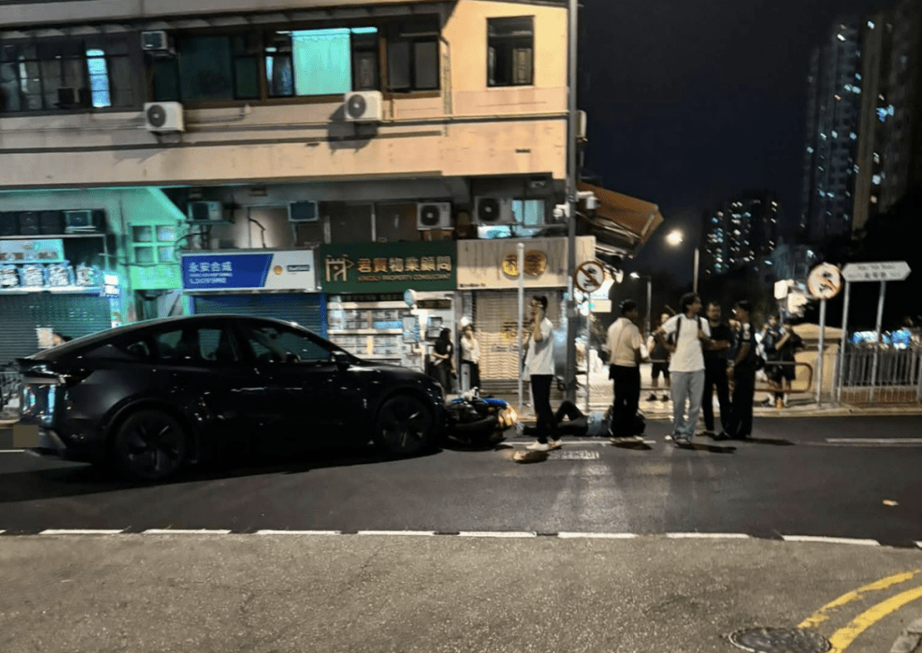 鐵騎士倒地期間,多名途人上前了解其傷勢,並疑用手機報案;私家車則橫亘路中。fb@馬路的事 (即時交通資訊台) 鐵騎士倒地期間,多名途人上前了解其傷勢,並疑用手機報案;私家車則橫亘路中。fb@馬路的事 (即時交通資訊台)