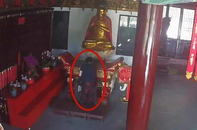 上海女子從寺廟功德箱裏偷走香油錢。上海警方 上海女子從寺廟功德箱裏偷走香油錢。上海警方