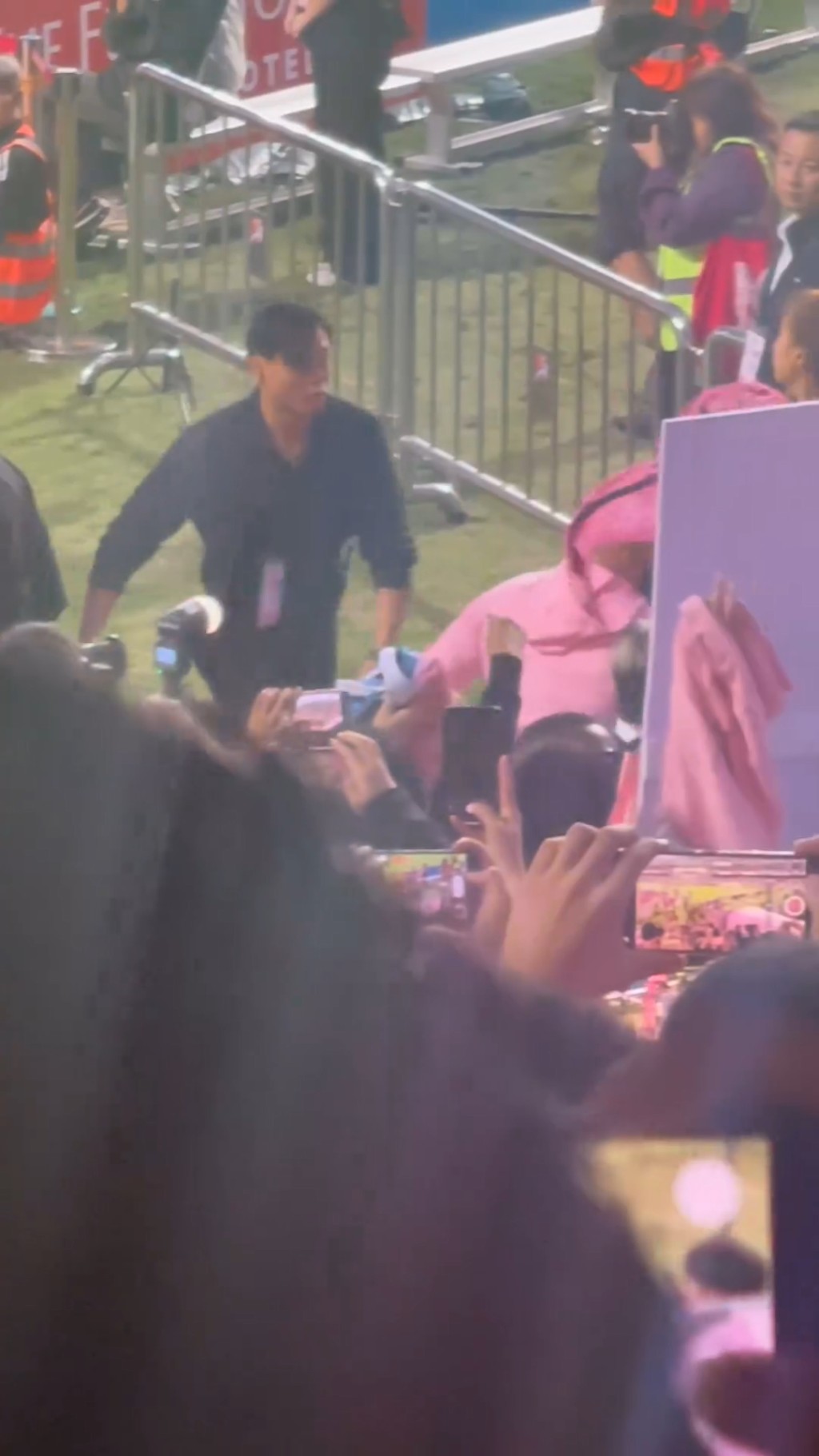 突然有球迷从被观众席的人群中，将一件粉红的球衣扔中了美斯。