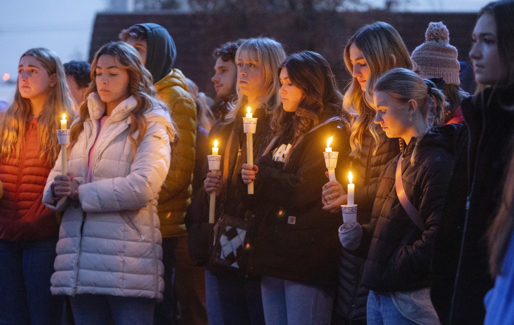 學生們點起蠟燭悼念4名死者。美聯社