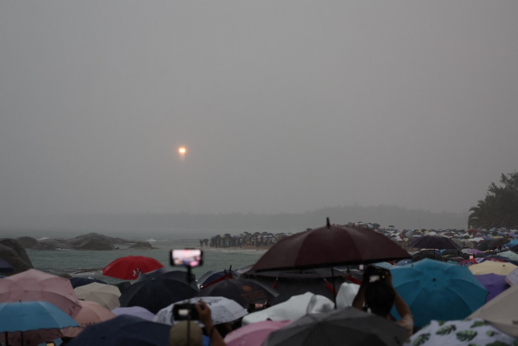大批民眾在海邊觀看「嫦娥奔月」。