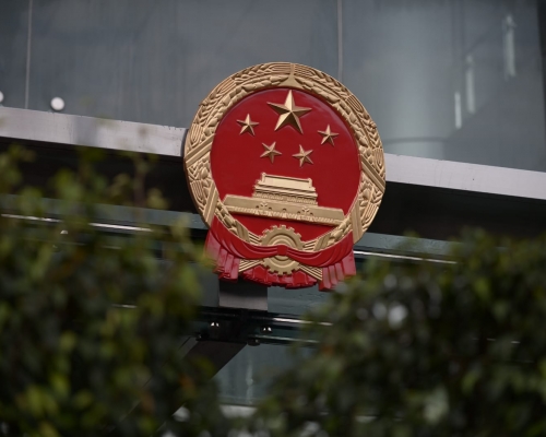 中联办职员深夜拆下被示威者弄污的国徽，换上新的。