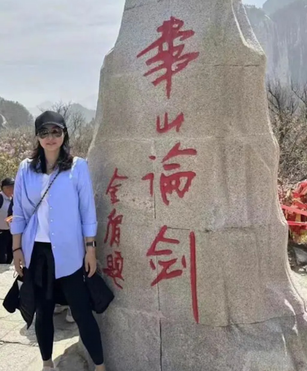 郭晶晶在金庸题字的「华山论剑」石前拍照。
