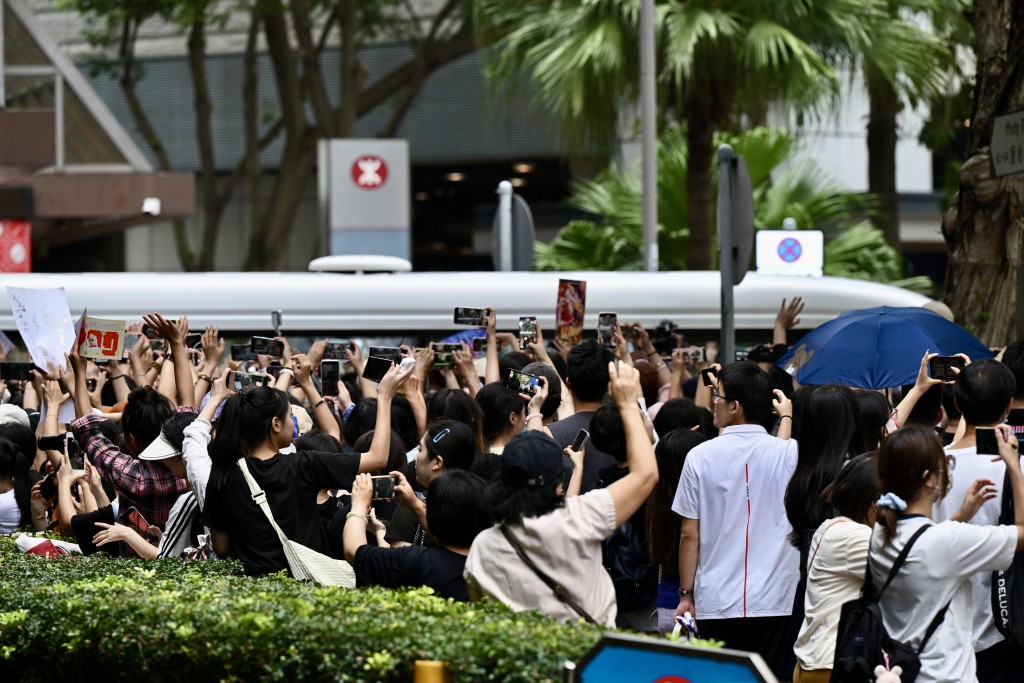 运动员乘坐的巴士离开时，不少市民冲前挥手送别。