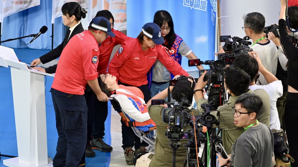 李清霞需由民安隊扶上輪椅。 李清霞需由民安隊扶上輪椅。