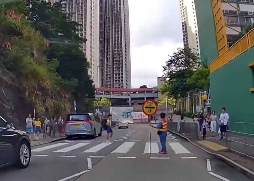 白色私家車駛走，有學童橫過斑馬線。fb車cam L（香港群組）影片截圖