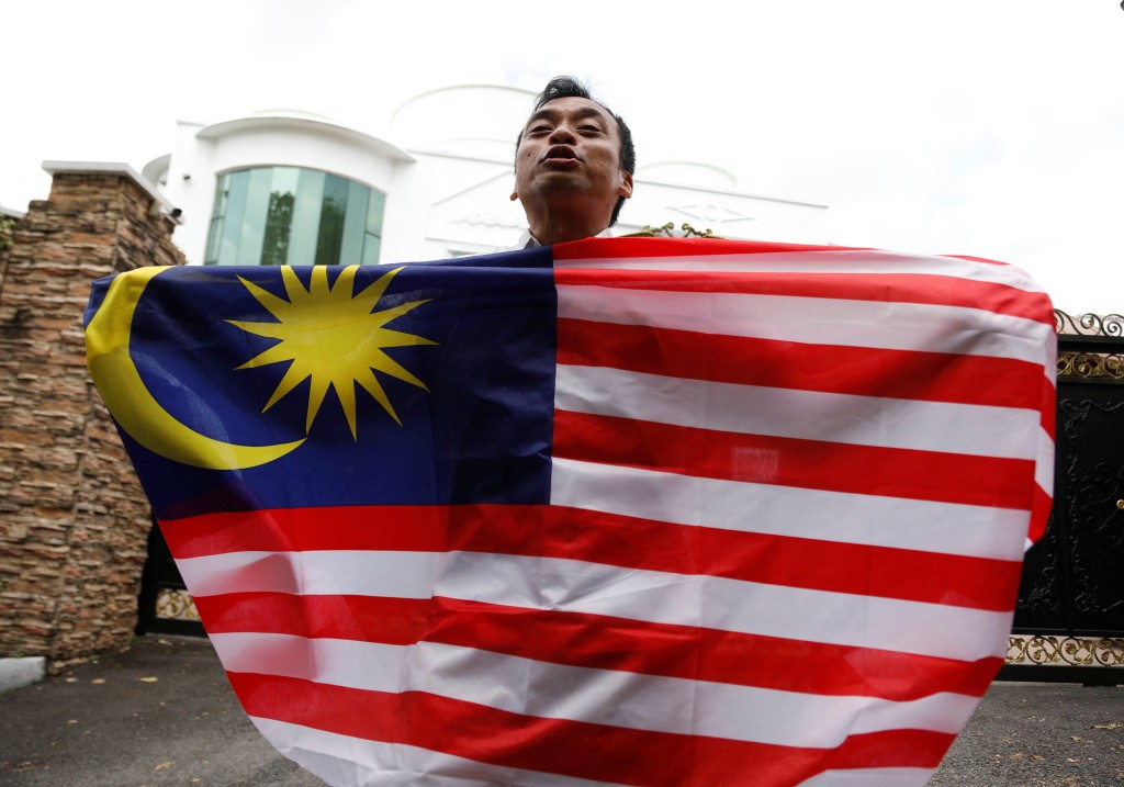 安華的支持者手持馬來西亞國旗。路透社資料圖片