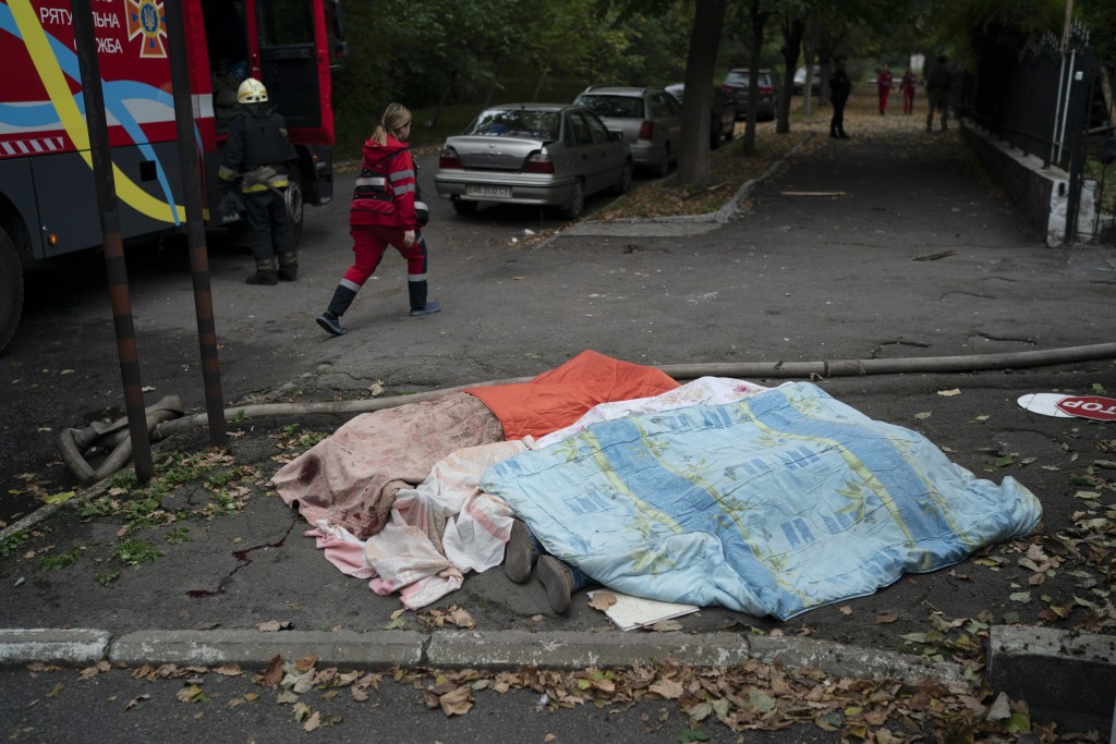 在基輔街頭，救援人員將三具屍體蓋上毯子。AP