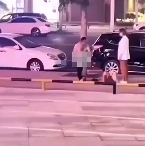 赤膊微胖男正在馬路旁脫褲子。網上截圖