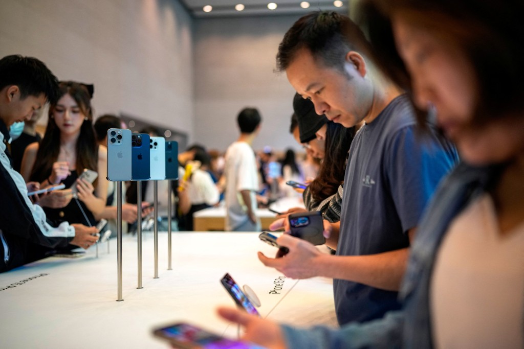 蘋果 iPhone 15 在上海的一家蘋果專賣店正式發售時，人們正在圍觀試用。路透社