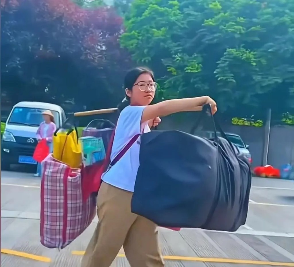扁擔女孩劉燕搬行李回家的形象,在網上爆紅。網圖 扁擔女孩劉燕搬行李回家的形象,在網上爆紅。網圖