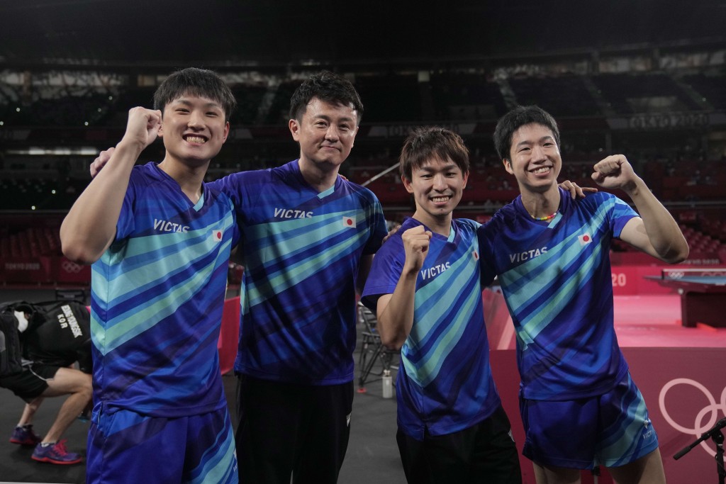 張本智和、教練倉島洋介、丹羽孝希及水谷隼握拳慶祝勝利。 AP