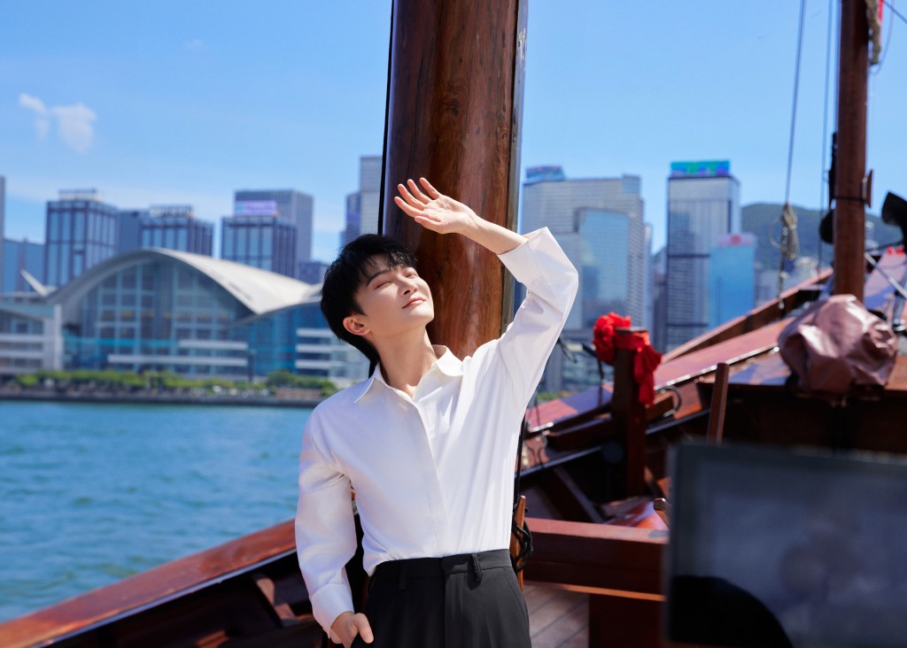 周深在標志性紅色帆船上大讚香港迷人的天際綫。旅發局提供