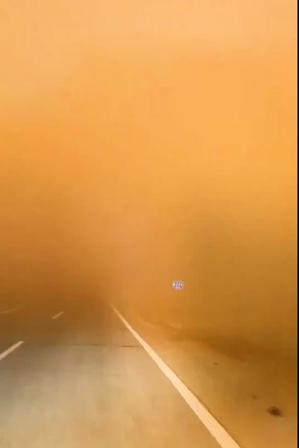 新疆的强烈沙尘暴，令公路视野只有数十米。影片截图