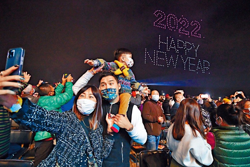 ■市民在無人機做出的二○二二年快樂新年慶祝字句下,打卡留住一家人一起跨年的美麗時刻。