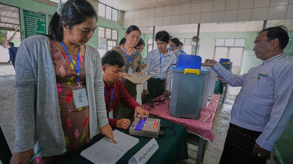 緬甸大選｜選委會職員及義工在仰光一票站測試電子投票機。 美聯社
