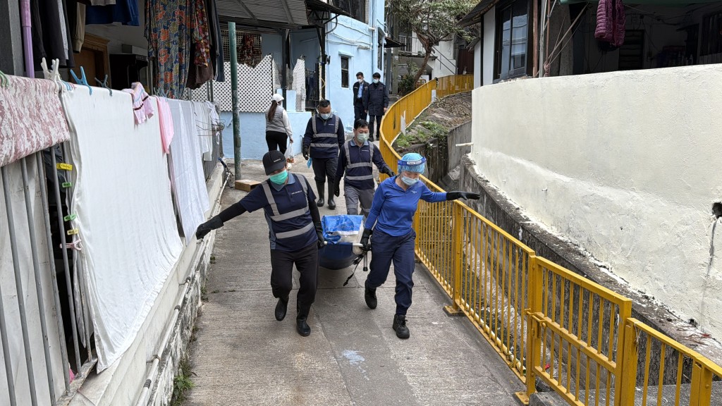 仵工將遺體移送殮房。
