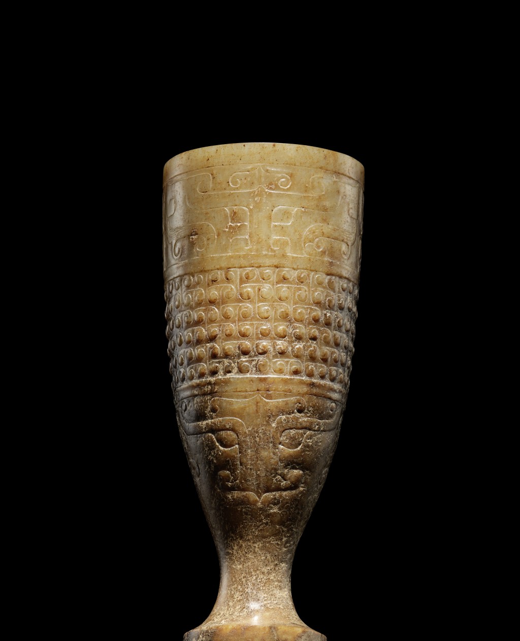 西汉玉浅浮雕兽面勾连云纹单把高足杯，高10.7厘米，估价：900,000- 1,200,000港元。