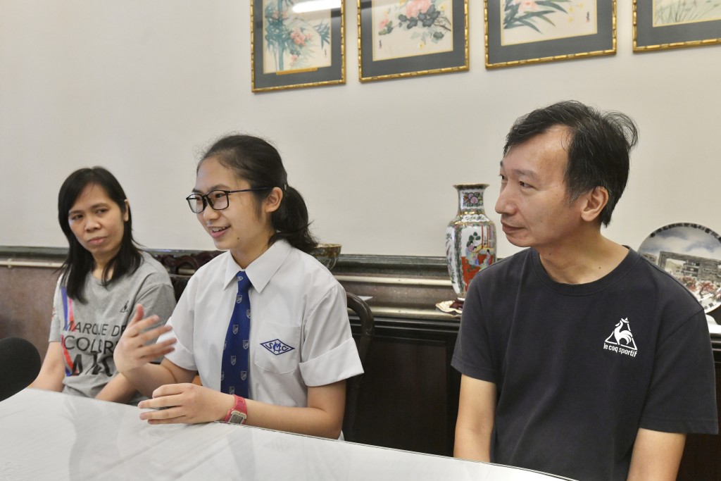 考取榜眼成绩的考生邹思悦（中）与父母接受访问。卢江球摄