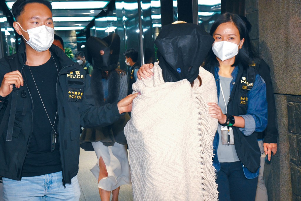 涉嫌「無牌行醫」被捕的兩名女子蒙頭帶署扣查。