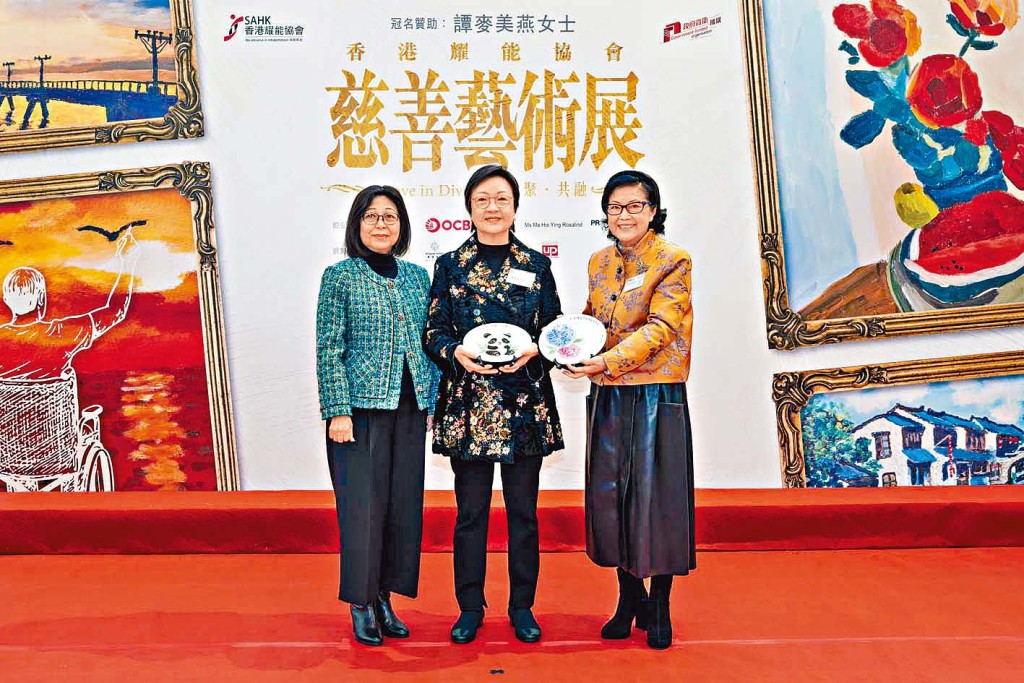 行政長官夫人李林麗嬋女士和彭太（右一）將與天耀工場學員共同創作的熊貓及繡球花瓷畫，送贈予活動冠名贊助商譚麥美燕女士（中）作為謝禮。（政府新聞處圖片）