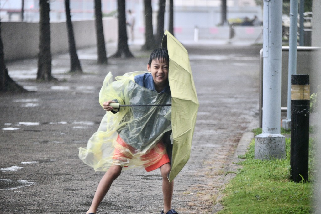雨伞变成了小朋友的「盾牌」。卢江球摄