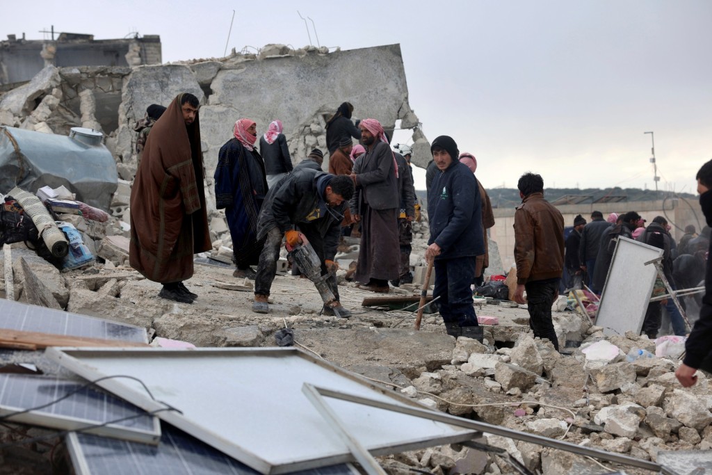 在敍利亞災區，人們用地鑽鑿開混凝土。  美聯社